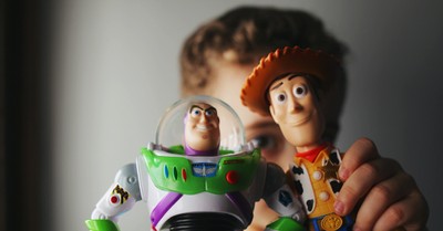 A kid holding a Buzz Lightyear and Woody toy, steps to relationships that transform