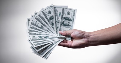 $100 bills in a person's hand, Group steals around 3/4 of a million dollars from churches