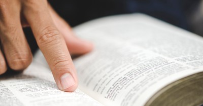 a person pointing at a Bible, Student loses points for referring to God as male