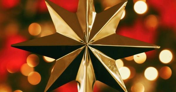 Gold Christmas star with red twinkling light background, what is Christmas