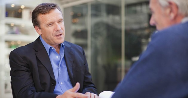 men having a discussion over a table