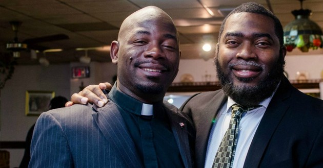 man shoulder-hugging pastor, both smiling proudly