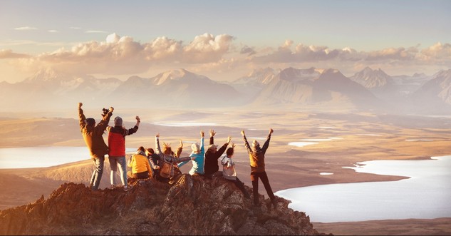 People cheering on top of a mountain