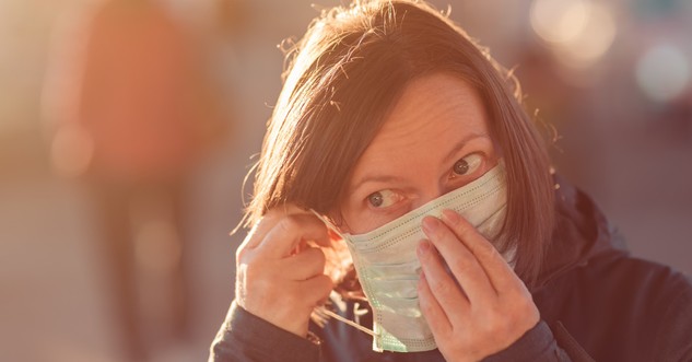 woman putting on face mask for COVID-19