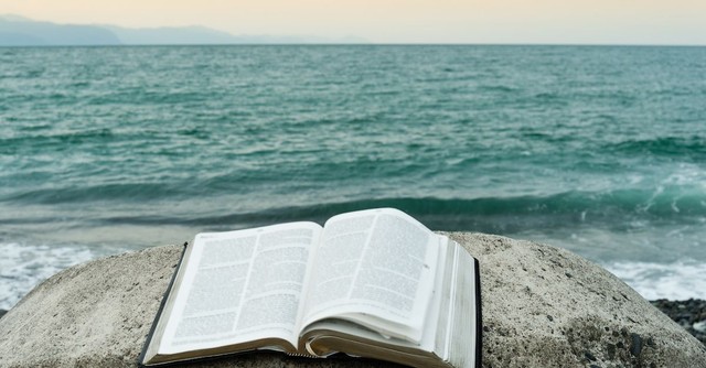 Open bible near an ocean