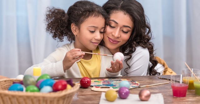 Mom and daughter painting Easter eggs
