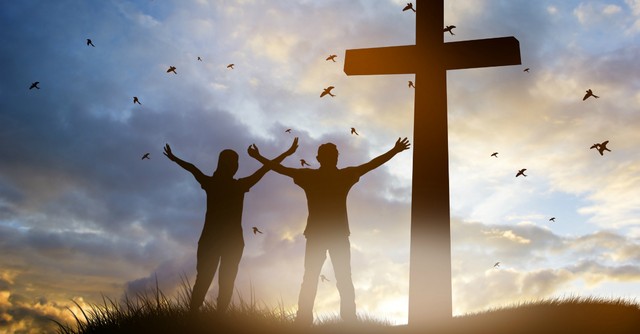 Man and woman celebrating before the cross