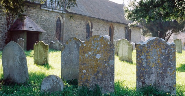 Old, weathered tombstones in a church graveyard