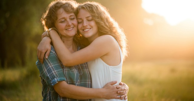 Mom and teenage daughter hugging