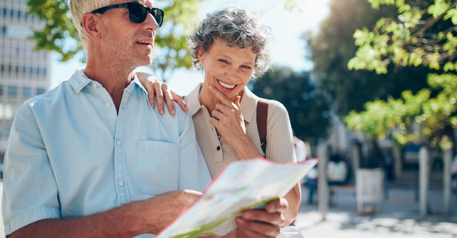 Happy senior couple navigating with a map