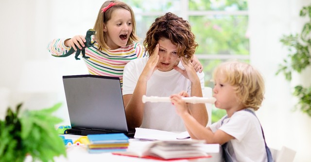 Stressed out mom with loud kids playing around her