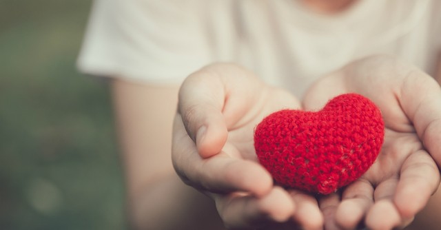 hands offering a red crocheted heart giving kindness, blessed are the pure in heart