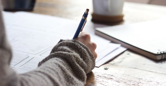 Woman journaling with a pen