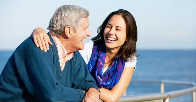 adult woman hugging dad at beach