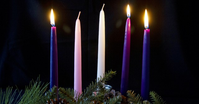 advent wreath and three lit candles with black background