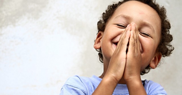 close up of happy little boy praying