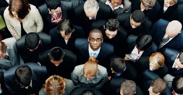 A businessman in a crowd looking up