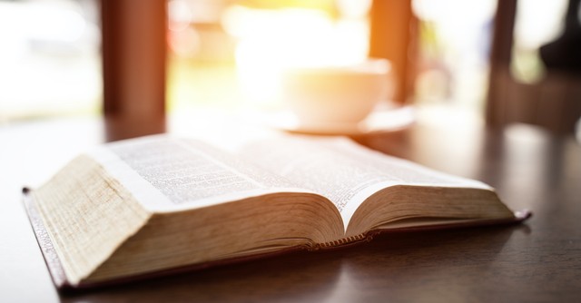 open Bible on table with bright background