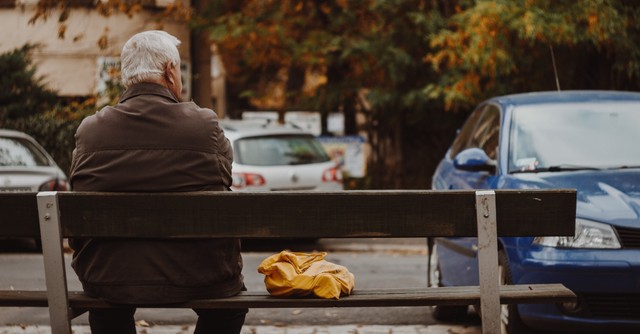 Men sitting on a bench waiting