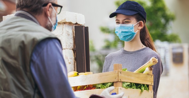 Young woman delivering groceries to an elderly man
