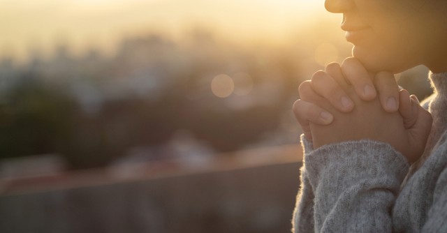 Woman praying at sunset