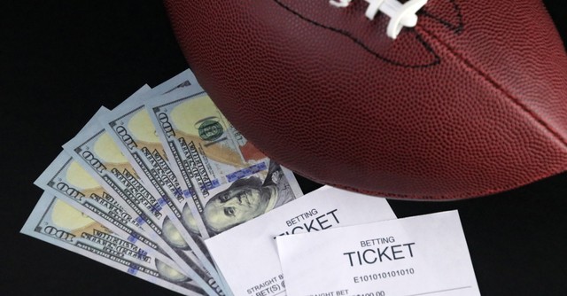 A football with money and sports betting tickets