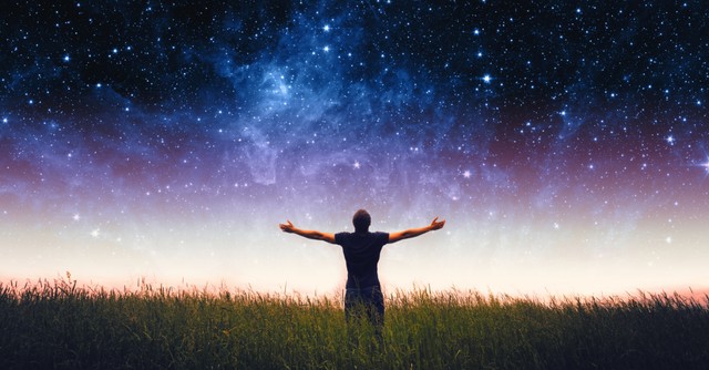 a man looking up to the heavens with his arms raised in praise