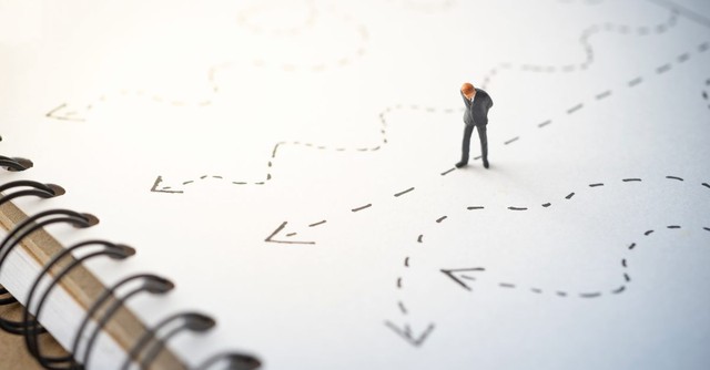 Man looking at multiple lines leading to one path