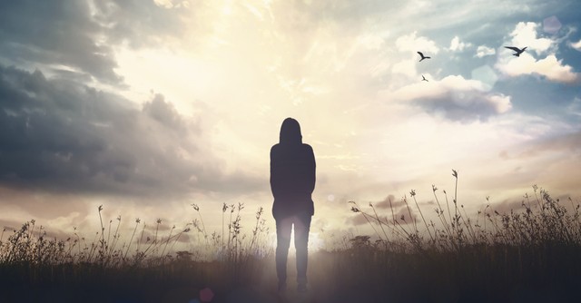 a woman looking out into the sunrise