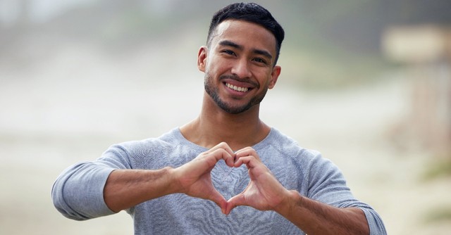 Man holding up hands in a heart shape