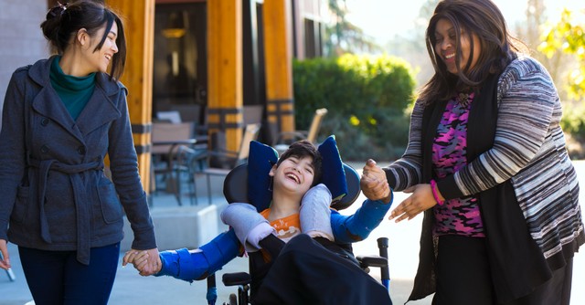 Two women with a boy in a wheelchair
