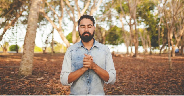 Man praying alone in the woods