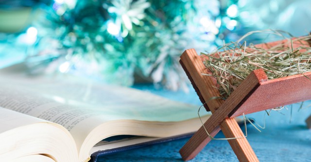 Small manger next to an open Bible