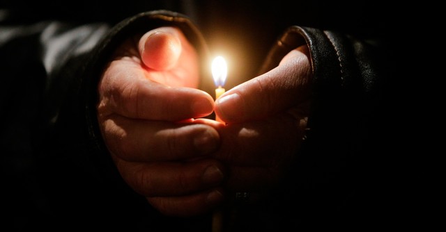 Person holding a candle in their hands