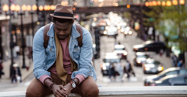 Worried man sitting on a curb