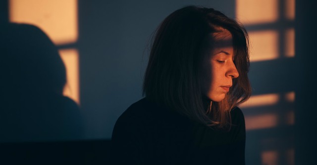 Sad woman sitting alone in the dark