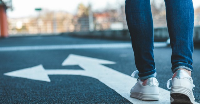 Woman walking on a path with arrows