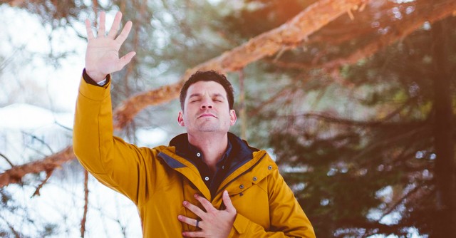 Man praying with hand over heart