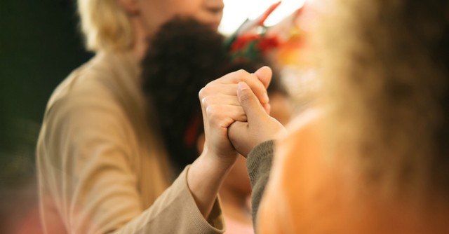 Women holding hands in prayer together