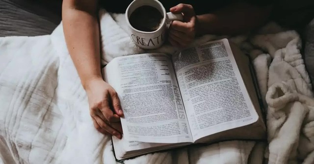 man reading the Bible with coffee