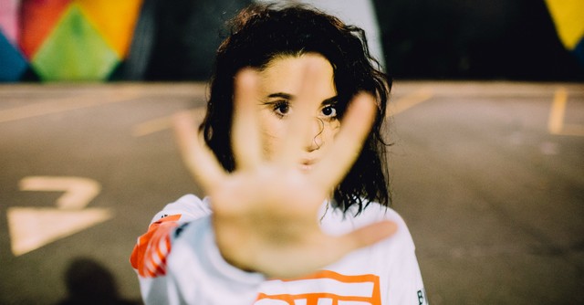 Woman with hand toward the camera