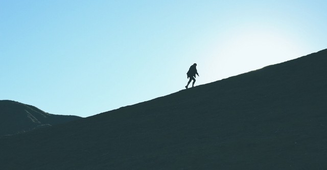 Single person climbing a mountain alone