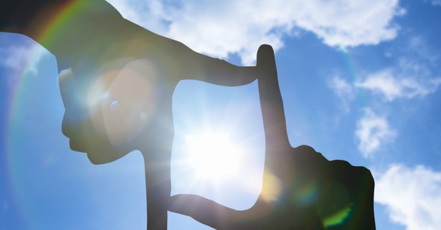 Fingers framing the sun