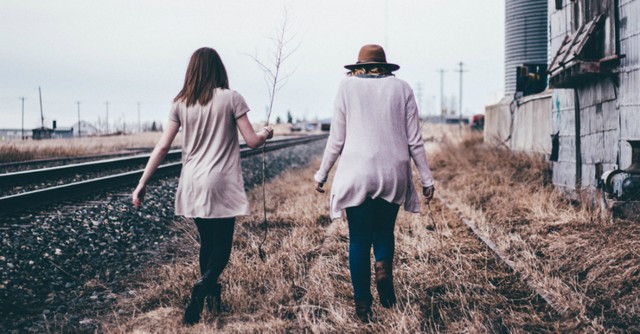 women friends walking by train track