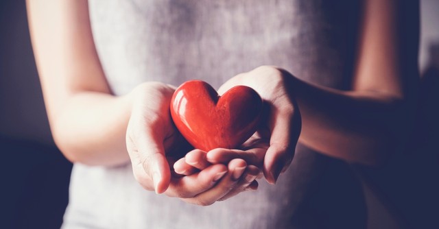 Woman holding a plastic heart in her hands