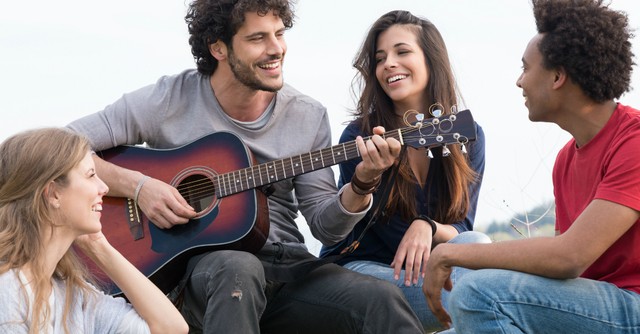 Group of friends playing guitar and singing