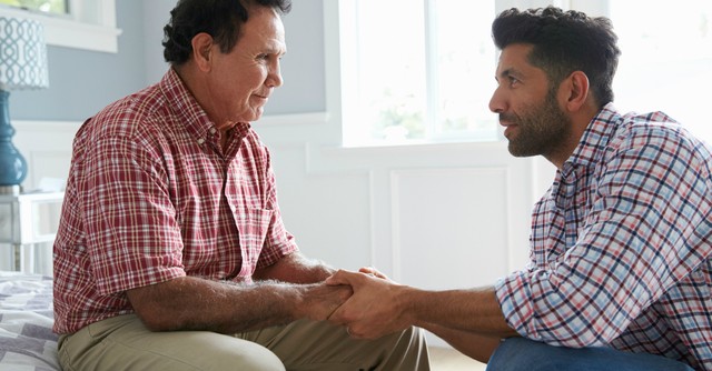adult child man holding hands of senior father dementia alzheimers