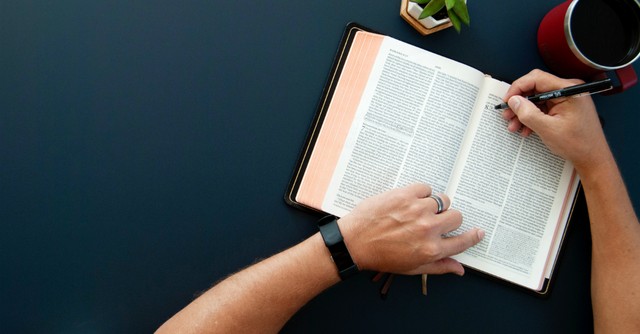 Open Bible and person writing, no rest for the wicked