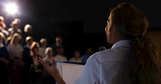 Woman speaking before a crowd, what is a false prophet