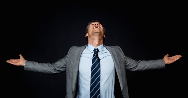 Businessman with arms out, looking up